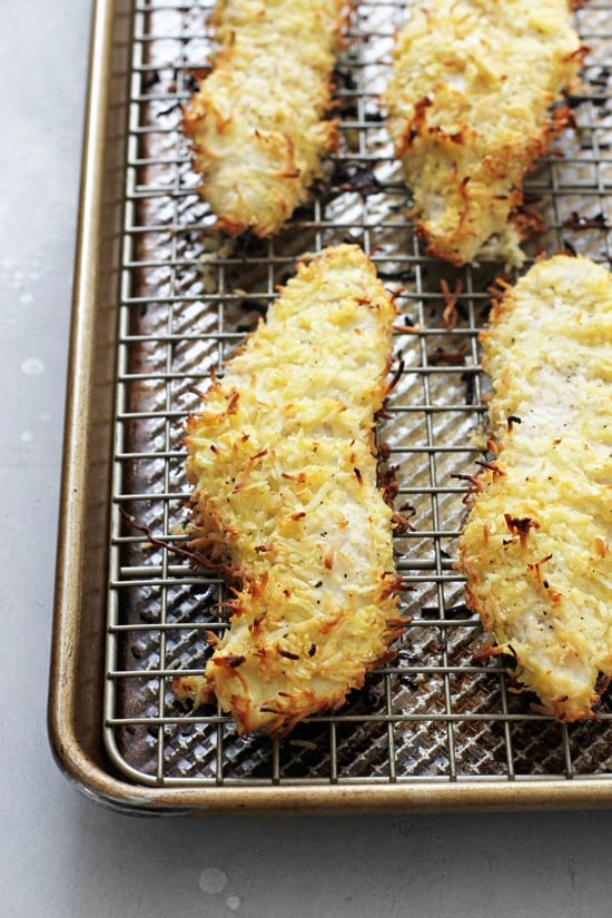 Several Coconut Chicken Strips on a baking sheet.