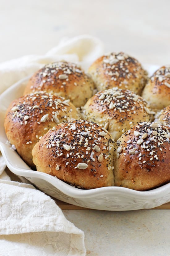 A white pie plate filled with Multigrain Rolls.