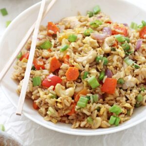 Make thai-style pineapple chicken fried rice at home! Simple, easy to make and much healthier than take-out! Packed with fresh veggies, brown rice, scrambled eggs and cashews!