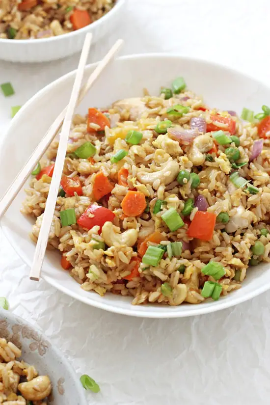 A white bowl filled with Pineapple Chicken Fried Rice and chopsticks.