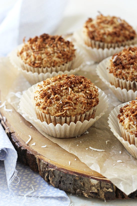 Several Coconut Muffins on a wooden serving platter.