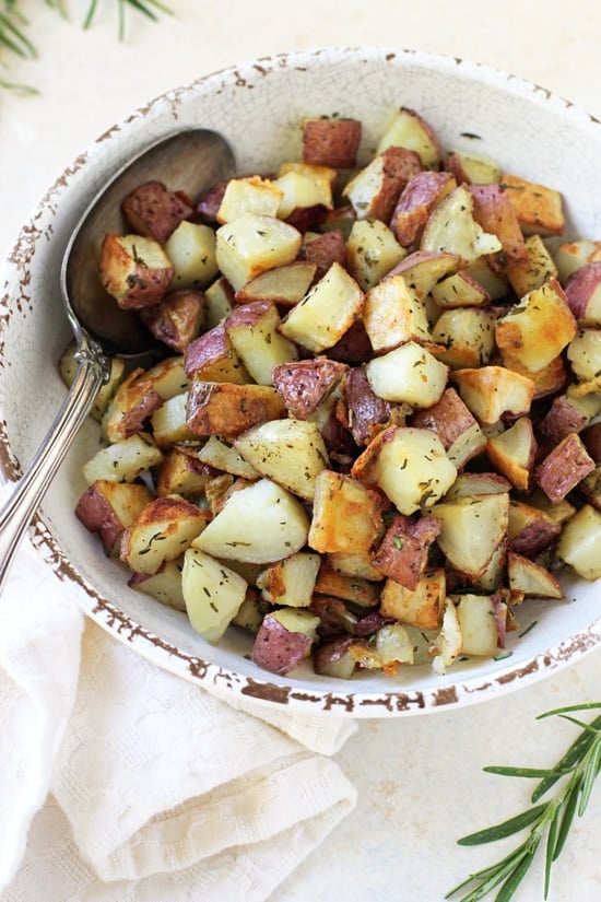 A white bowl filled with Oven Roasted Red Potatoes.