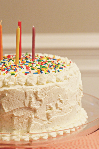 A Funfetti Layer Cake topped with sprinkles and candles.