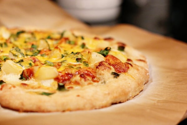 A BBQ Chicken Pineapple Pizza on parchment paper.