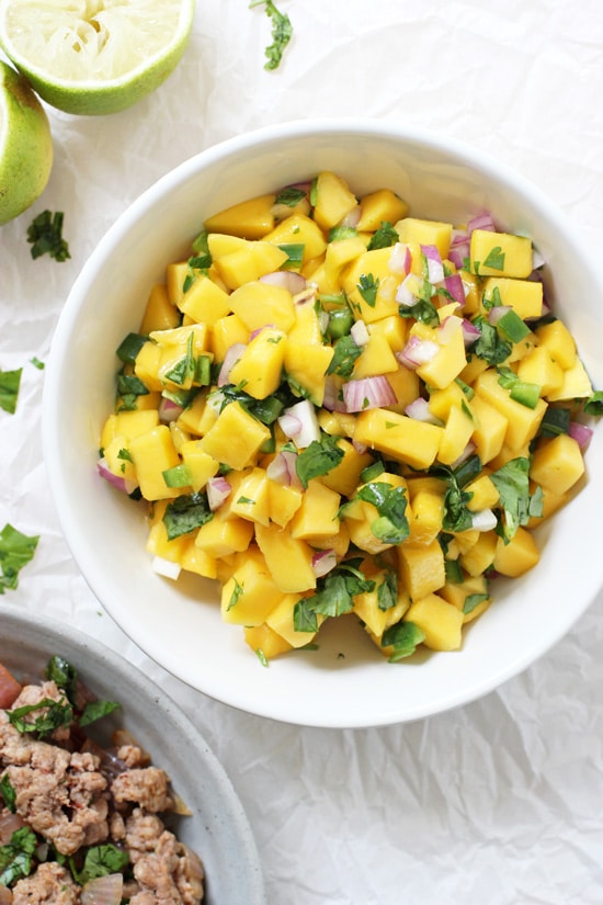A white bowl filled with Mango Salsa.