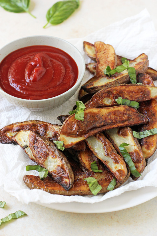 Baked Fries on a plate with a small bowl of ketchup.