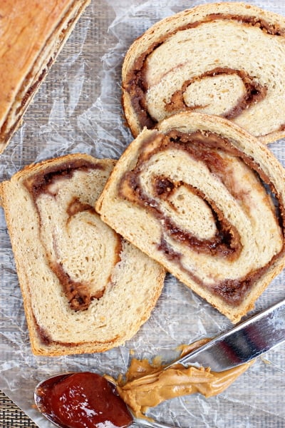 Three slices of Peanut Butter and Jelly Swirl Bread on wax paper.