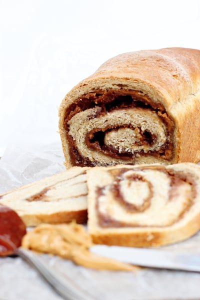 A loaf of Peanut Butter and Jelly Bread partially sliced.