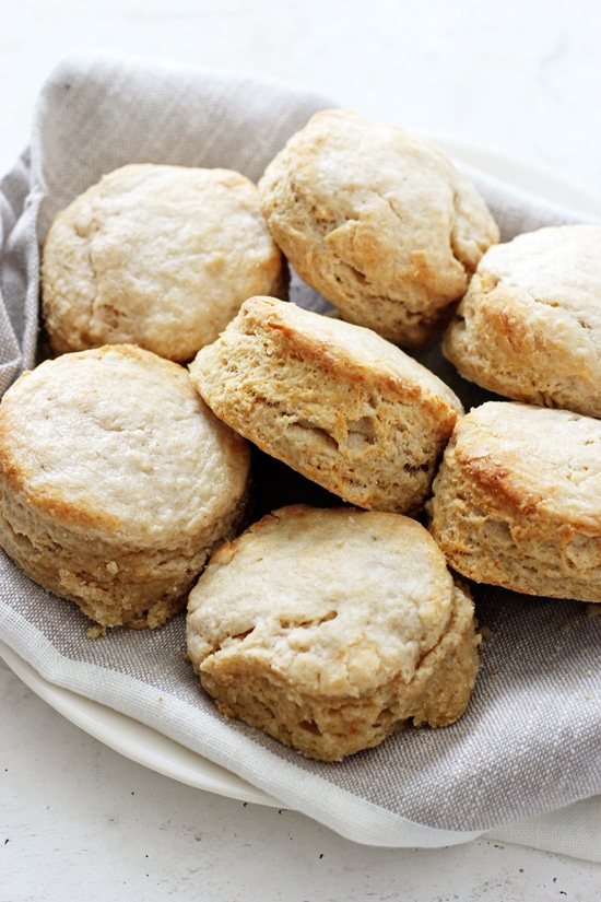 Several Coconut Milk Biscuits on a dish towel lined plate.