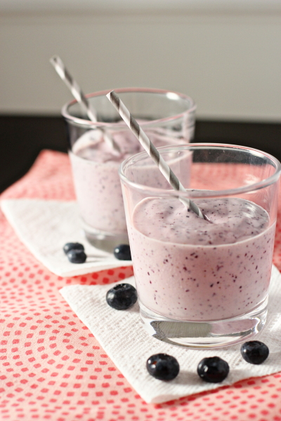Two Blueberry Mango Smoothies in glasses with grey straws.