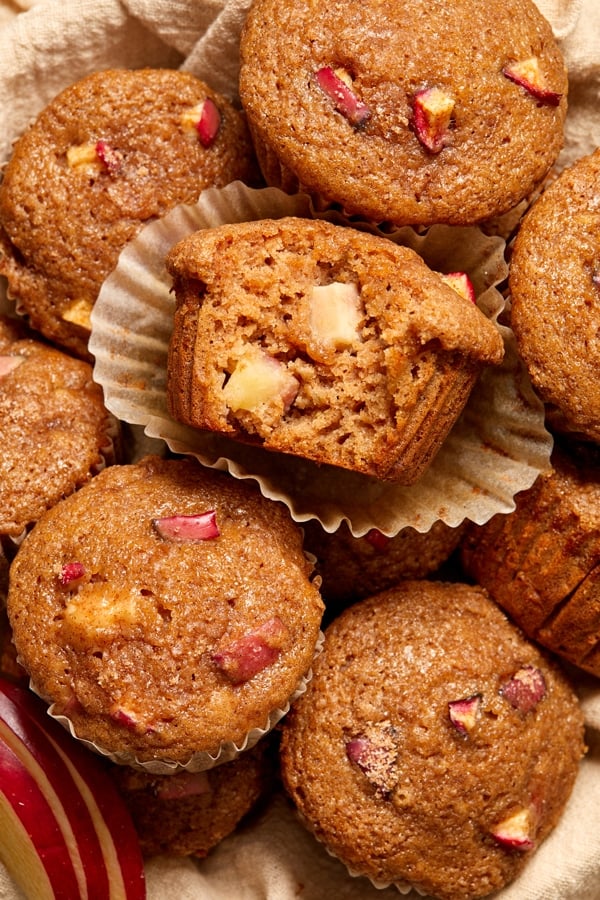 Dairy Free Apple Muffins piled in a basket with a bite out of one.