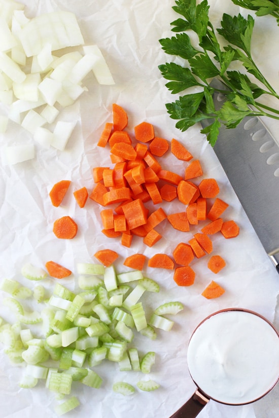 Chopped onion, carrot and celery on crinkled parchment paper.