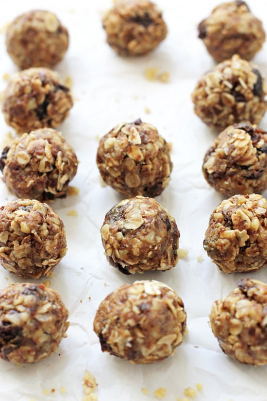 Several Oatmeal Raisin Energy Bites on white parchment paper.