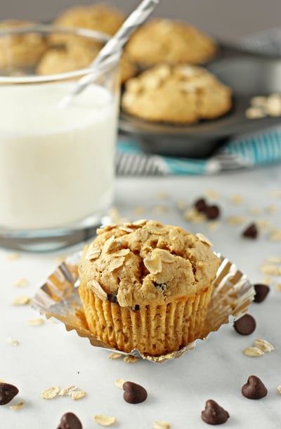 An unwrapped Peanut Butter Oatmeal Muffin with a glass of milk.