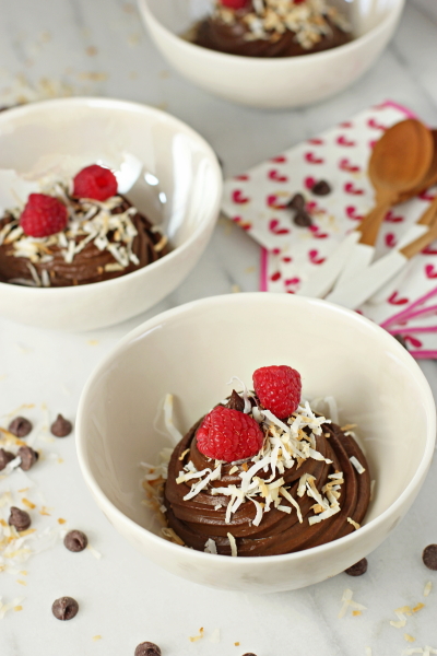 Three white bowls filled with Avocado Chocolate Mousse.