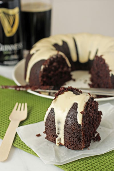 A slice of Chocolate Stout Bundt Cake with the full cake in the background.