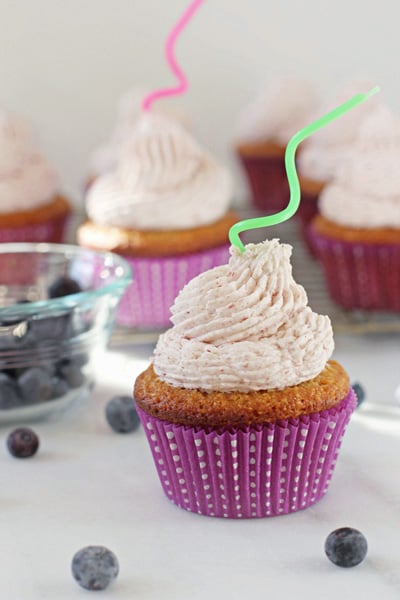 Almond Flour Cupcakes on a marble surface with fresh blueberries scattered around.