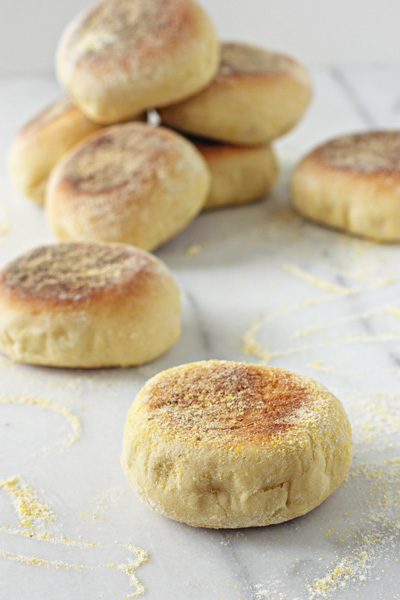 Several Homemade English Muffins on a marble surface.