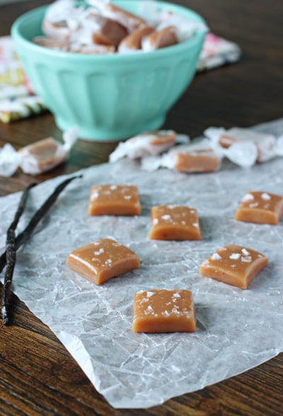 Several unwrapped Vanilla Bean Sea Salt Caramels on parchment paper.