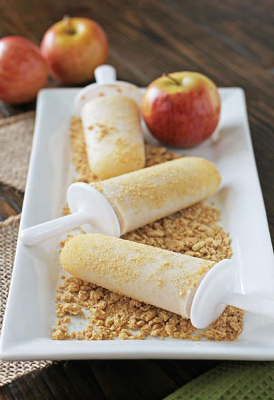 A few Apple Pie Popsicles on a serving platter with graham crackers.