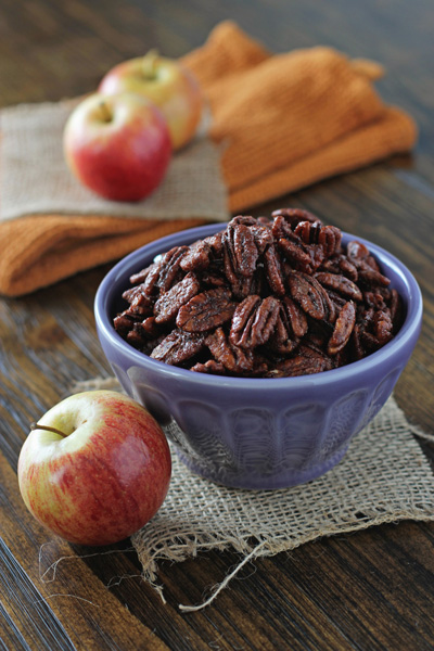 A purple bowl filled with Apple Pie Spiced Pecans.