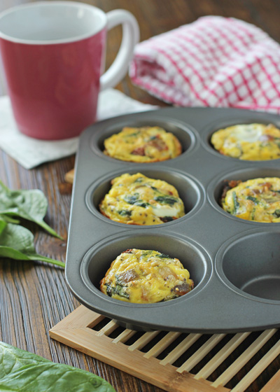 A muffin tin filled with Spinach and Sun-Dried Tomato Frittata Muffins.