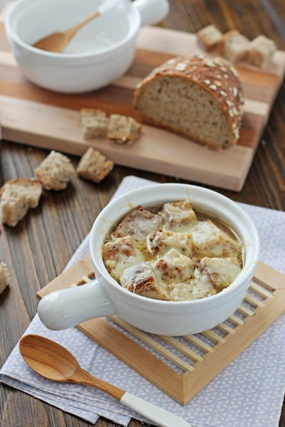 A white bowl filled with Slow Cooker French Onion Soup.