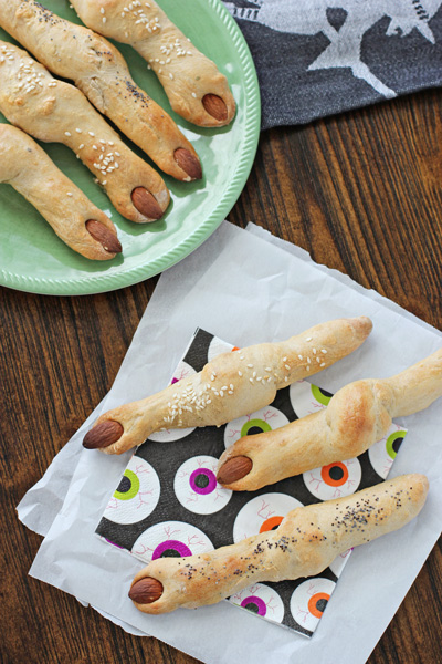 Several Witch Finger Breadsticks on napkins and a plate.