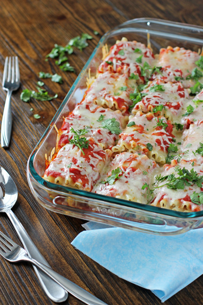 A glass baking dish filled with Mexican Lasagna Roll-Ups.