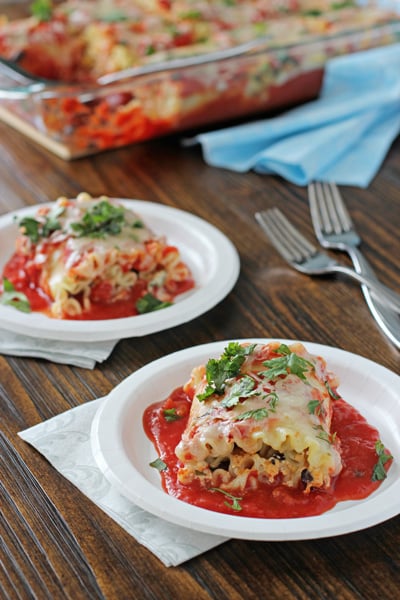 Two white plates with servings of Mexican Lasagna Roll-Ups.