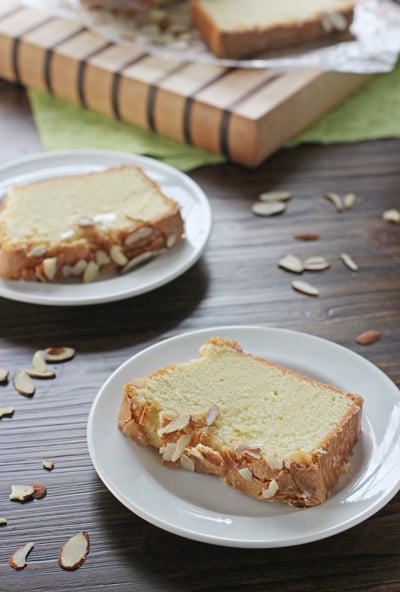 Two slices of Homemade Almond Pound Cake on white plates.