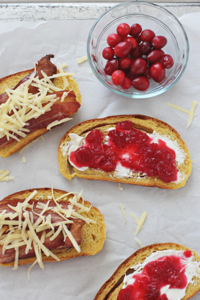 Uncooked Cranberry Grilled Cheese sandwiches on parchment paper.