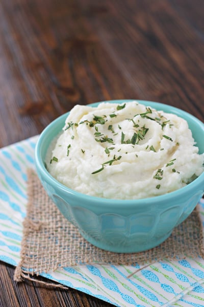An aqua serving bowl filled with Creamy Mashed Cauliflower.