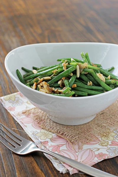 A serving bowl filled with French Green Beans with Almonds.