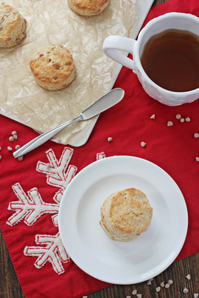 Eggnog Biscuits on a plate and baking sheet with tea to the side.