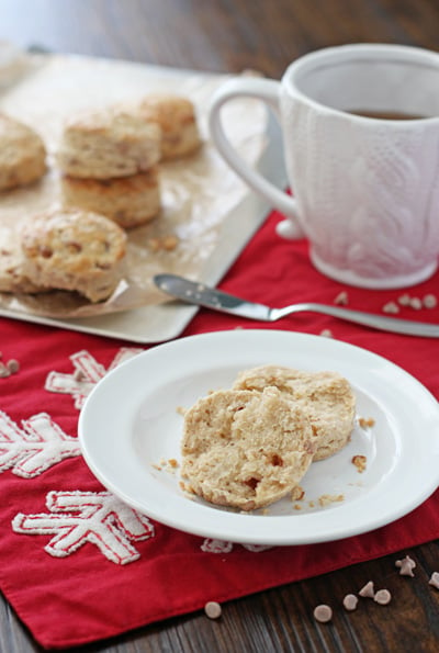 A split open Eggnog Biscuit on a plate with tea to the side.