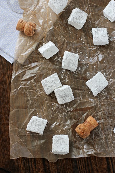 Champagne Marshmallows on parchment paper with two champagne corks.