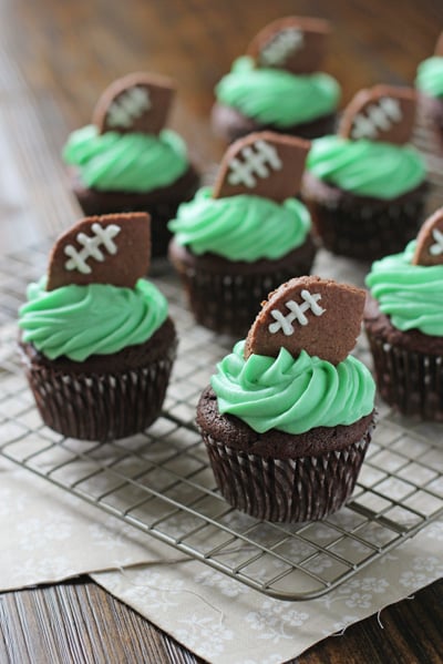 Several Football Themed Cupcakes on a cooling rack.