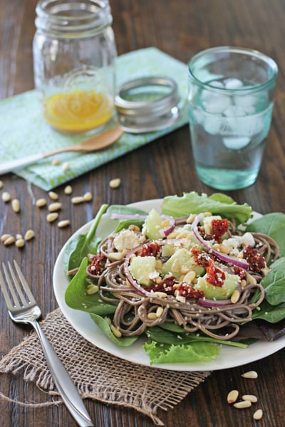 Soba Noodle Pine Nut Salad on a white plate with a fork to the side.