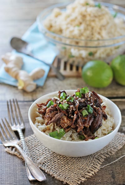 Crockpot Beef Short Ribs over rice in a white bowl with forks to the side.