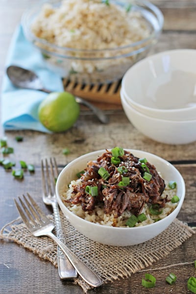 Crockpot Asian Short Ribs over rice in a white bowl.