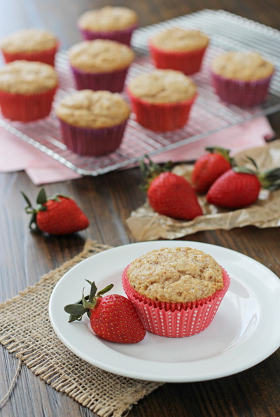 An Easy Strawberry Muffin on a plate with a fresh strawberry.