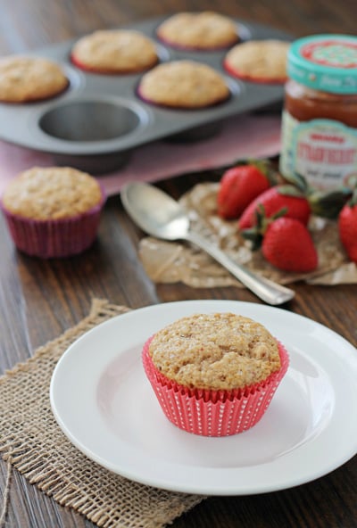 A Strawberry Vanilla Muffin on a plate with more in the background.