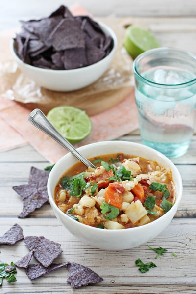 A white bowl of Chipotle Chicken Stew with tortilla chips to the side.