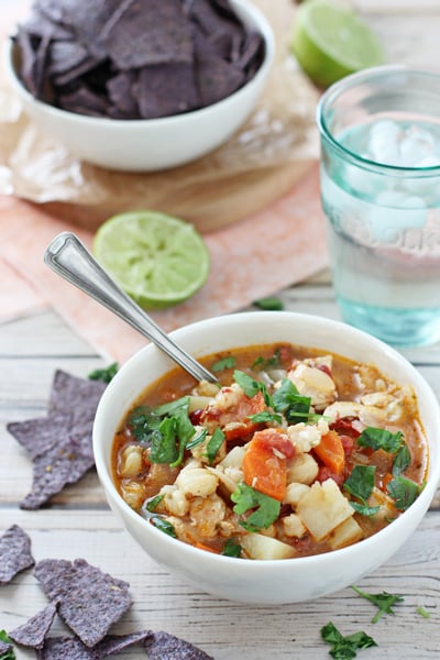 A white bowl of Chipotle Soup with a spoon in the dish.