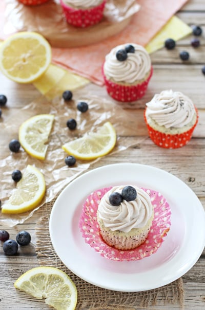 A Lemon Poppyseed Cupcake on a plate with more to the side.