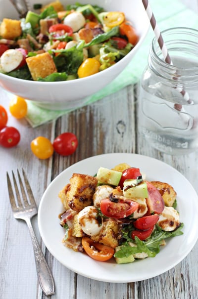 A white dish and serving bowl filled with Cornbread Panzanella.