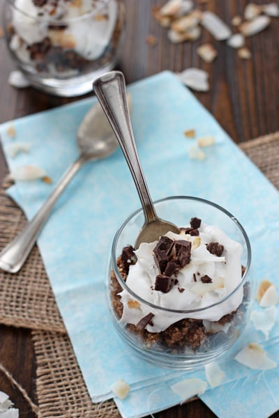 A glass jar with a Cookie Dough Parfait and a spoon in the dish.