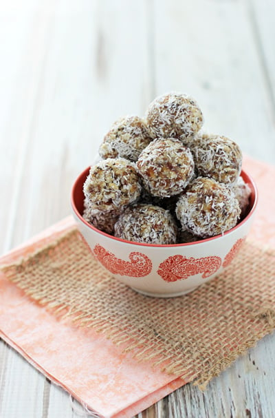 A white and coral dish filled with Lemon Coconut Energy Bites.