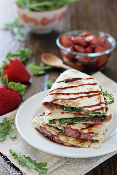 Several Brie Quesadillas stacked on a white plate.